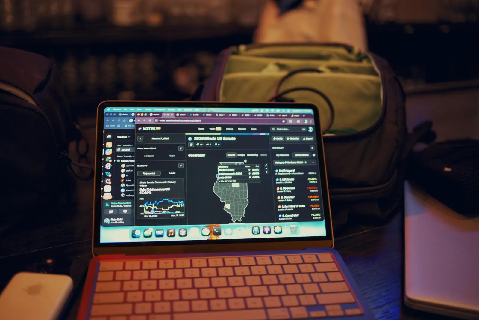 A laptop on a desk showing an Illinois results map, lit in red and blue.